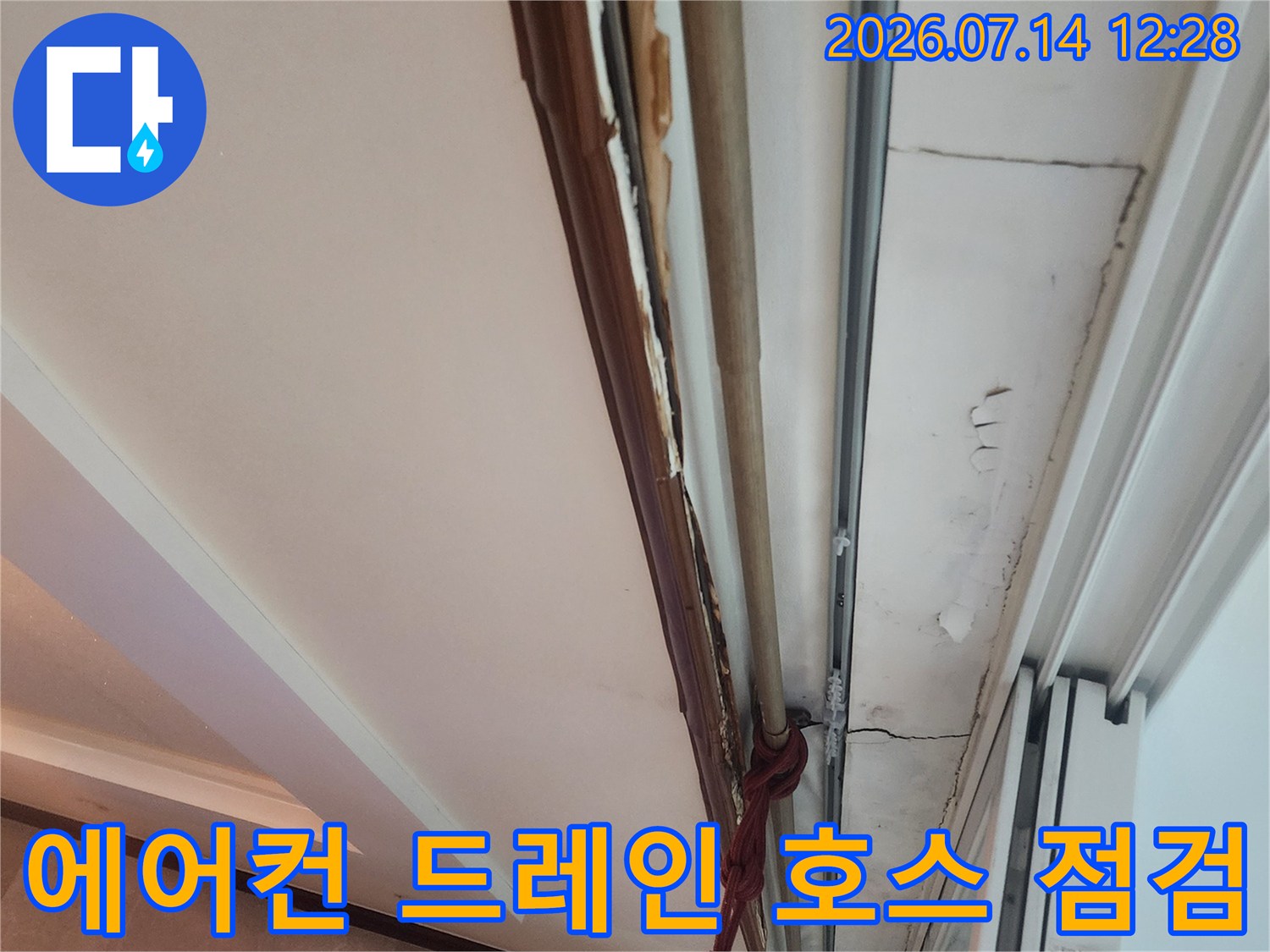 노출된 에어컨 배수 호스와 변색된 천장 몰딩 부위