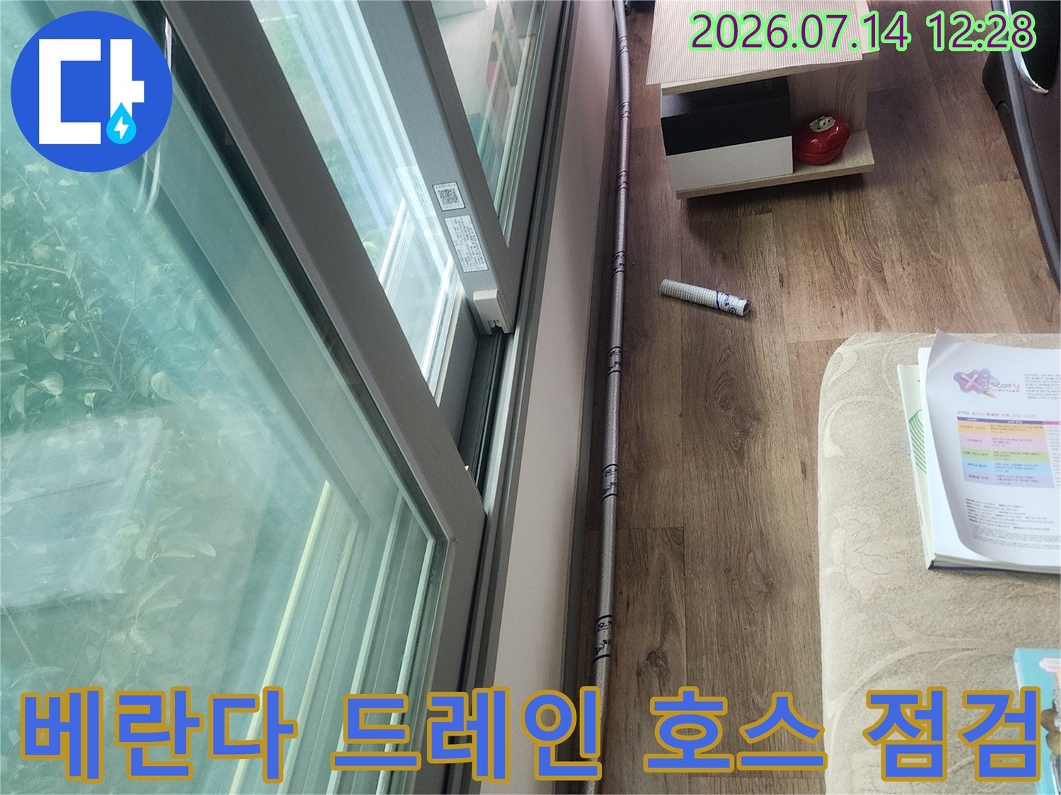 베란다 천장 아래로 노출된 에어컨 드레인 배수관을 정밀하게 점검하는 모습