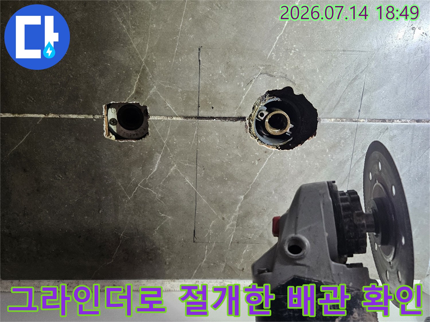 그라인더 장비를 사용하여 욕조 수전 부위의 타일을 제거하고 내부 배관을 노출시킨 모습
