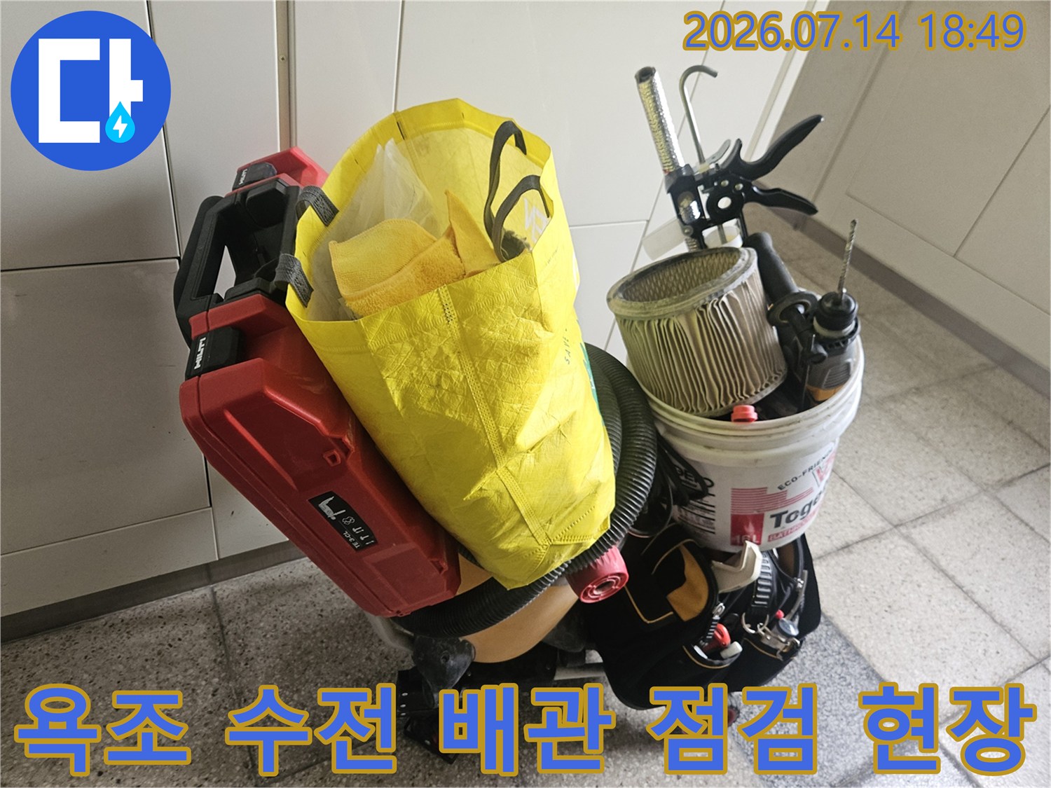 욕조 수전 부위의 파손된 타일과 노출된 배관 주변을 점검하는 장비들