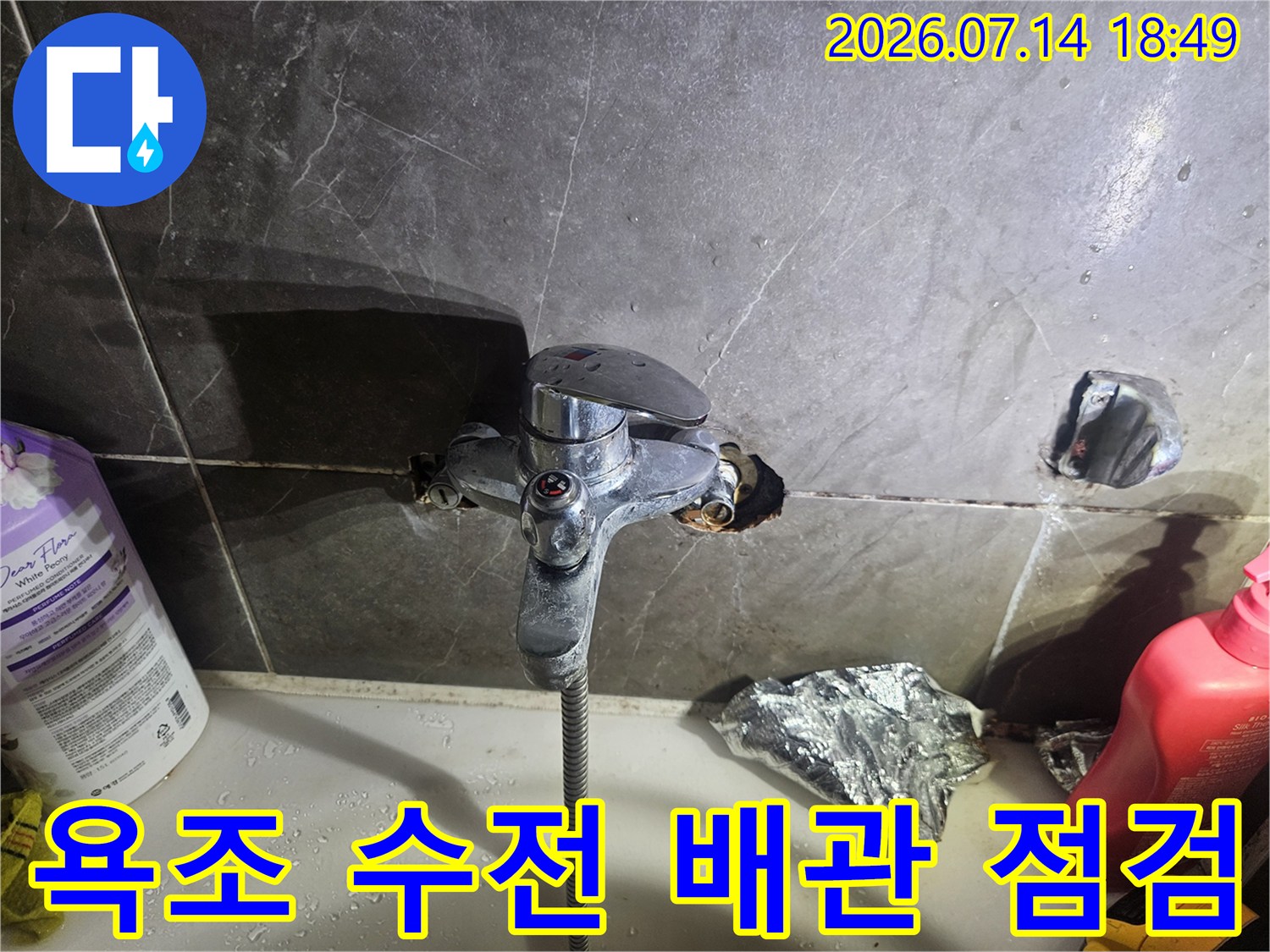 타일이 제거된 욕조 수전 부위의 노출 배관과 교체용 수전 장비