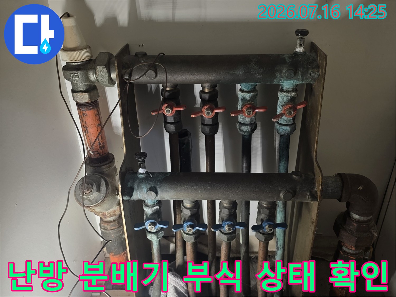 금속제 분배기의 노후된 외관과 배관 연결부의 부식 정도를 파악하는 사진