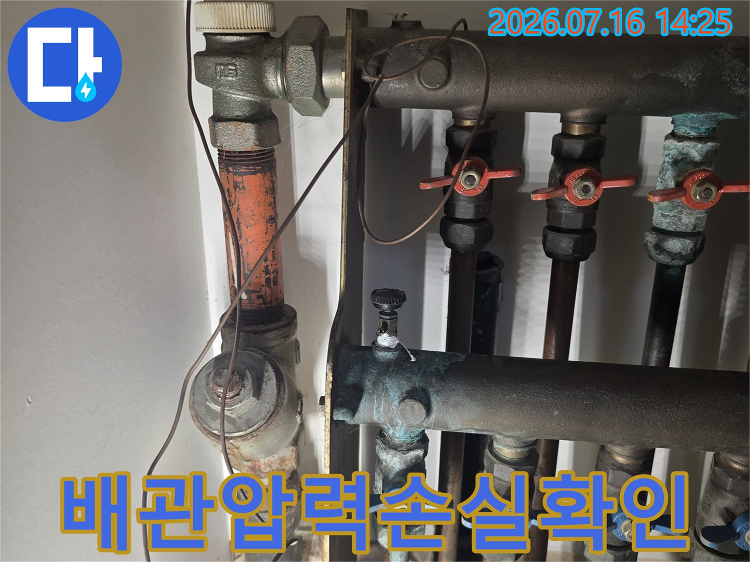 누수 지점을 찾기 위해 배관에 장비를 연결하여 압력을 점검하는 모습