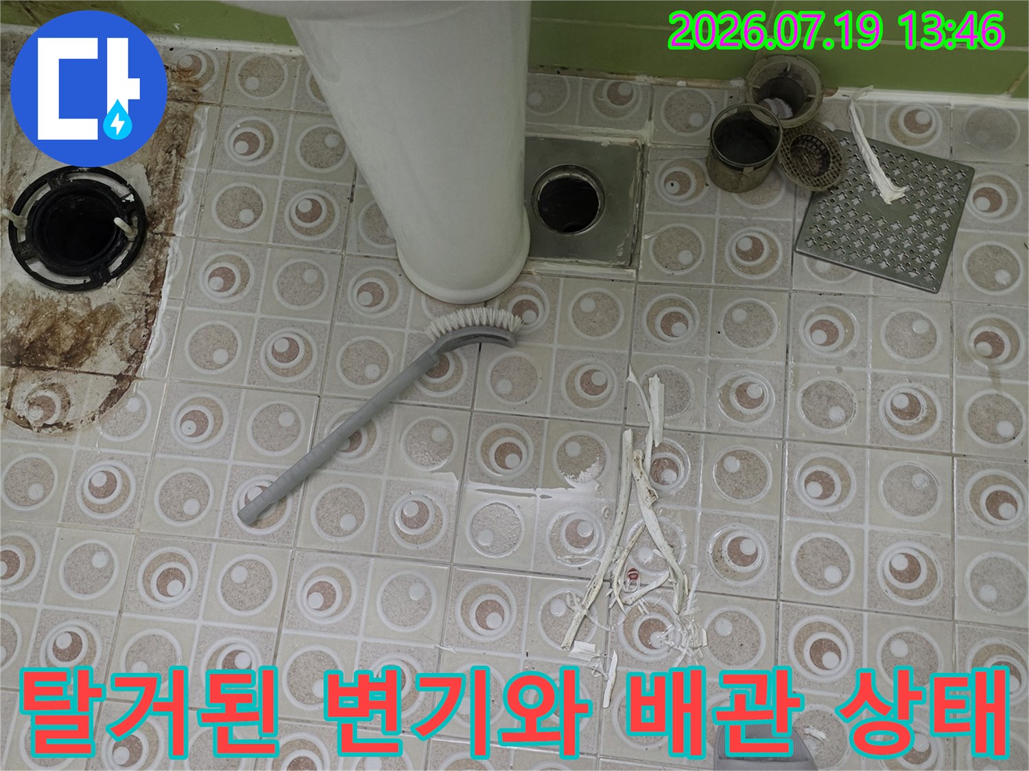 화장실 바닥에서 변기를 탈거하여 드러난 흰색 오수 배관과 주변 타일의 모습