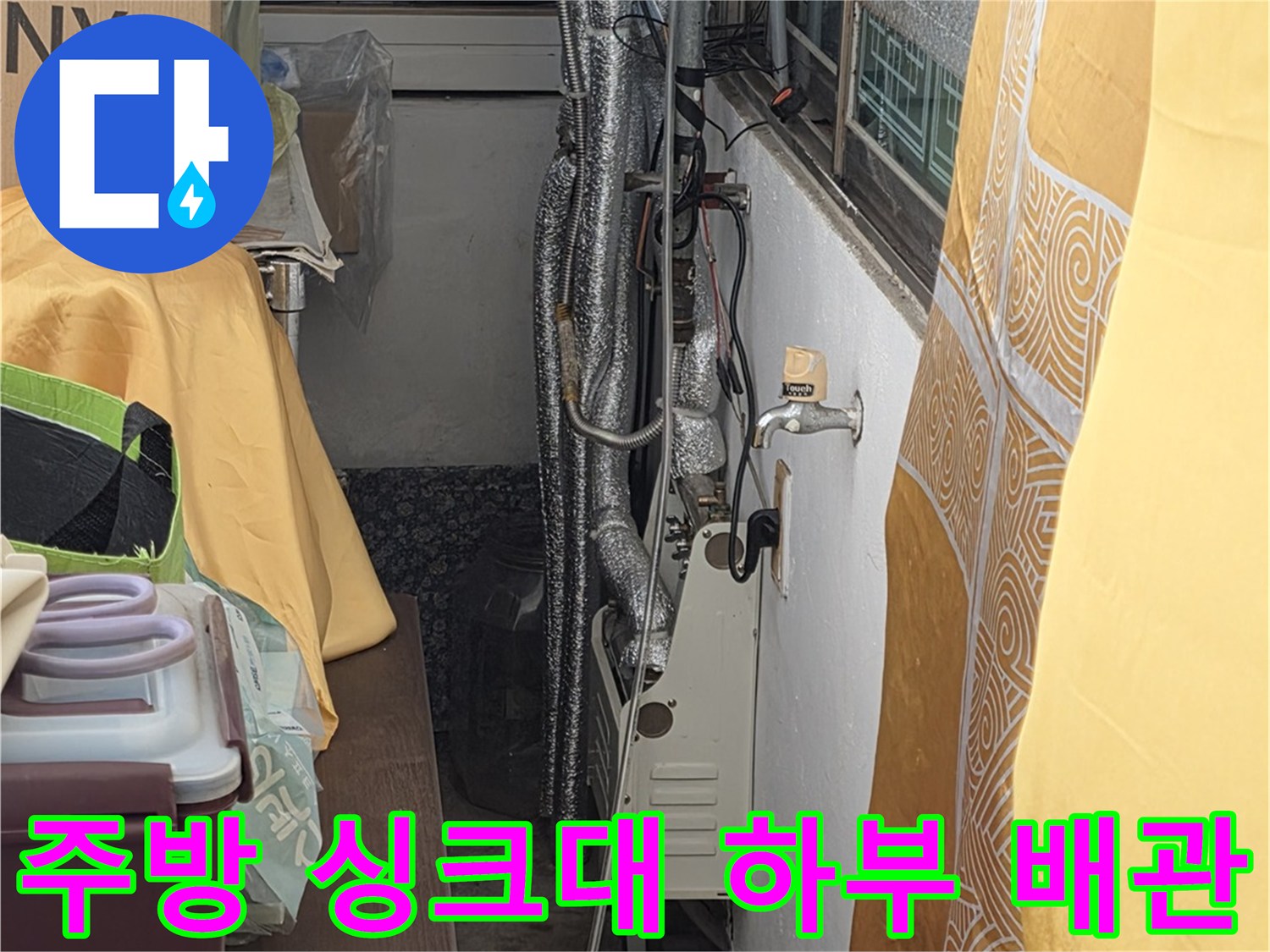 싱크대 밑 보온재가 씌워진 수도 연결 배관들