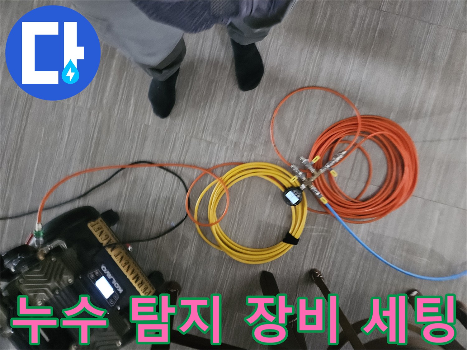 바닥에 놓인 배관 점검용 가스 탐지기와 호스들-정밀한 누수 위치 파악을 위한 준비 상황입니다.