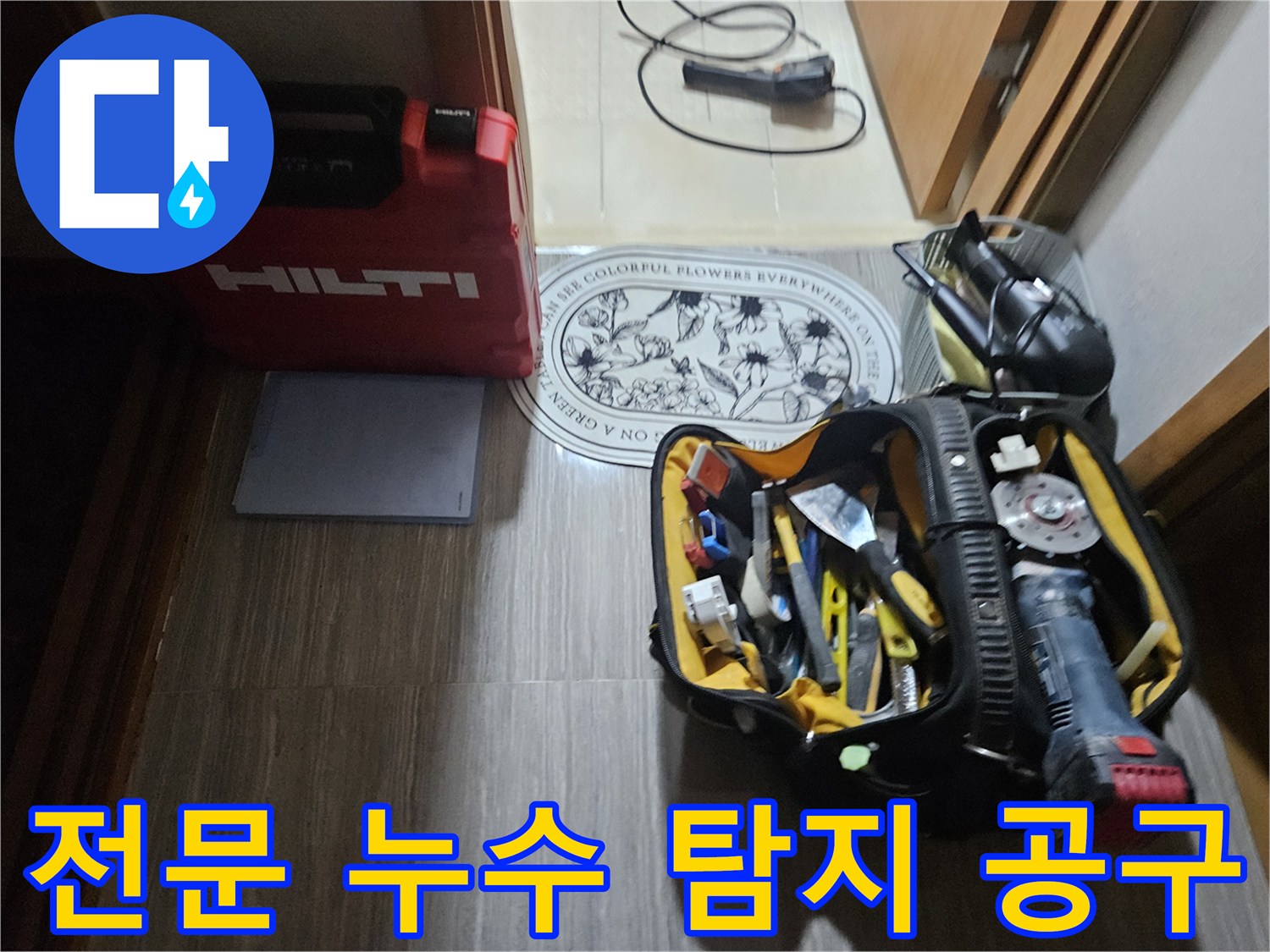 바닥에 놓인 힐티 케이스와 다양한 배관 수리용 수공구 세트