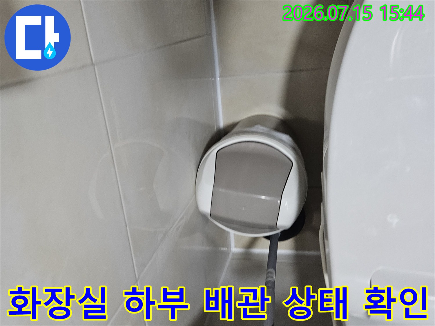 세면대 아래쪽 노출된 배관을 점검하여 누수 원인을 파악하는 현장 사진