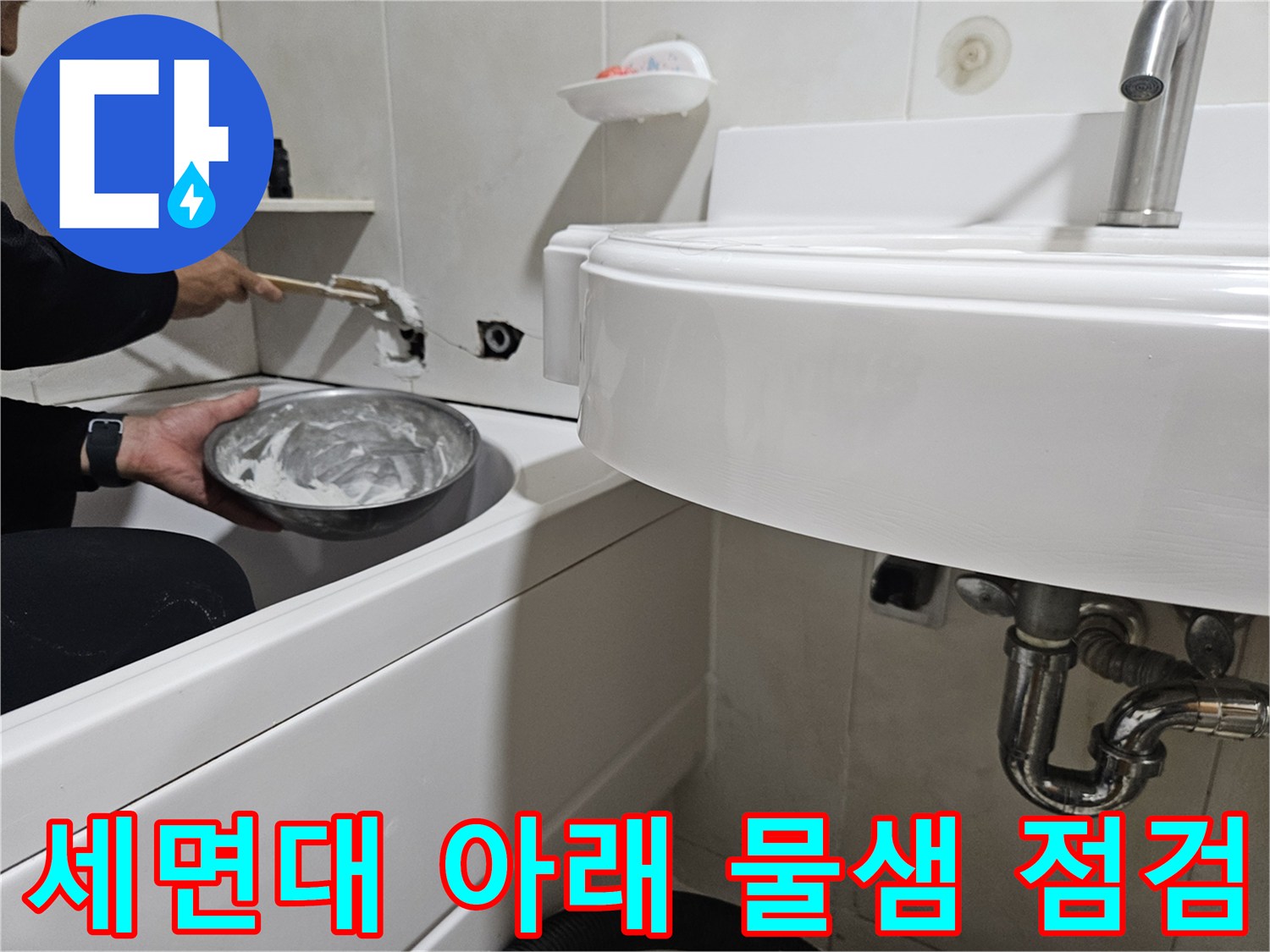 세면대 아래쪽 배관 연결 상태를 정밀하게 조사하는 장면입니다.