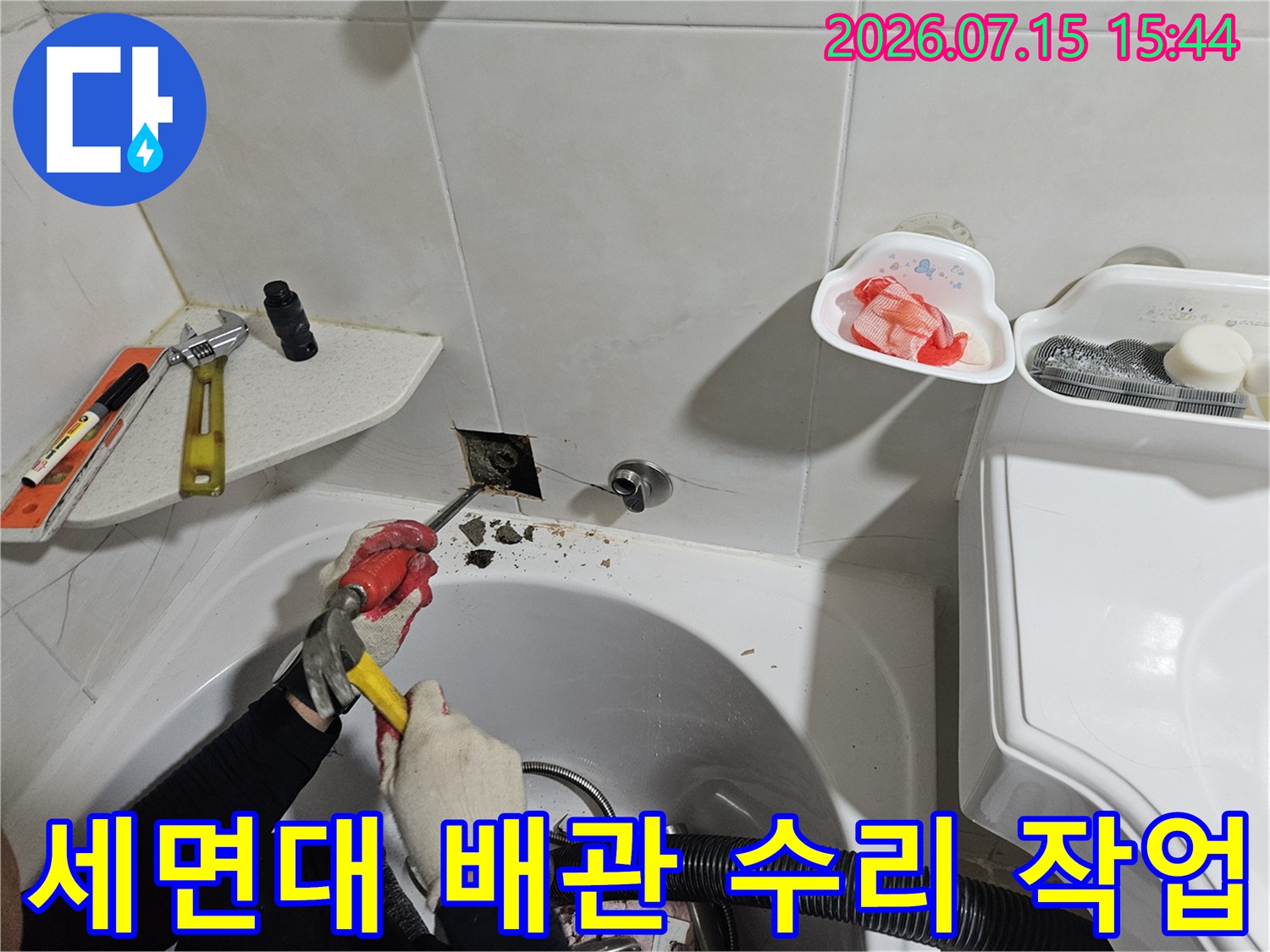 전문가가 세면대 아래 배관을 분해하고 새 부속으로 교체하는 장면