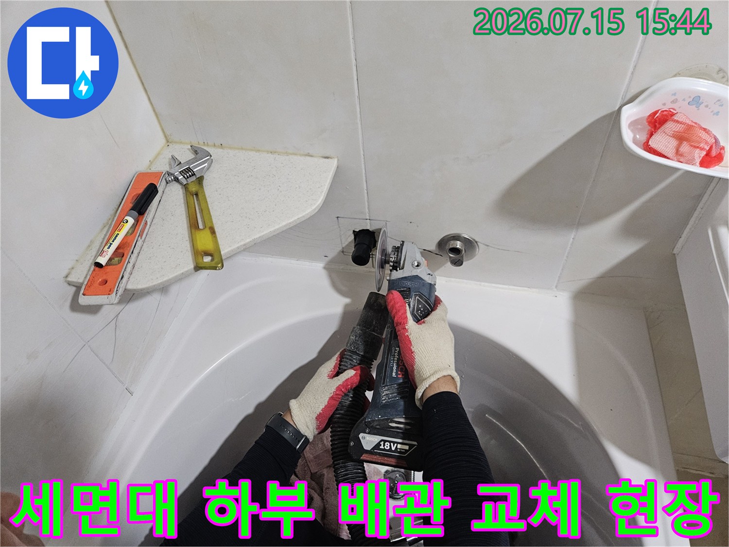 전문적인 기술로 세면대 아래 노후된 수도 배관을 분해하고 새 부속으로 장착하는 장면