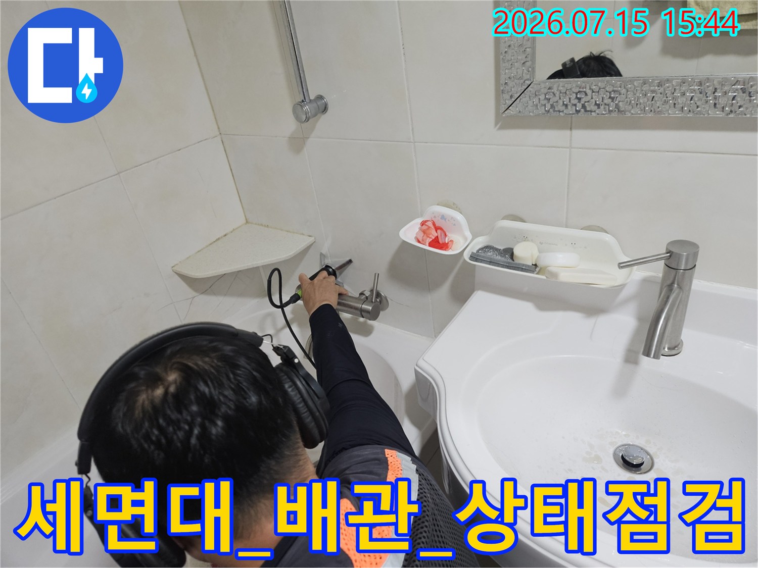 청음 장비를 착용한 기술자가 세면대 아래쪽 배관의 누수 여부를 정밀하게 체크하는 사진