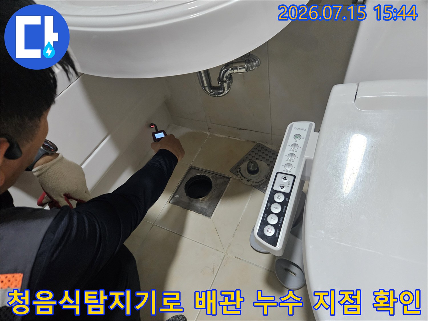 청음식 탐지기 장비를 활용하여 화장실 세면대 아래 배관의 누수 위치를 정밀하게 추적하는 모습