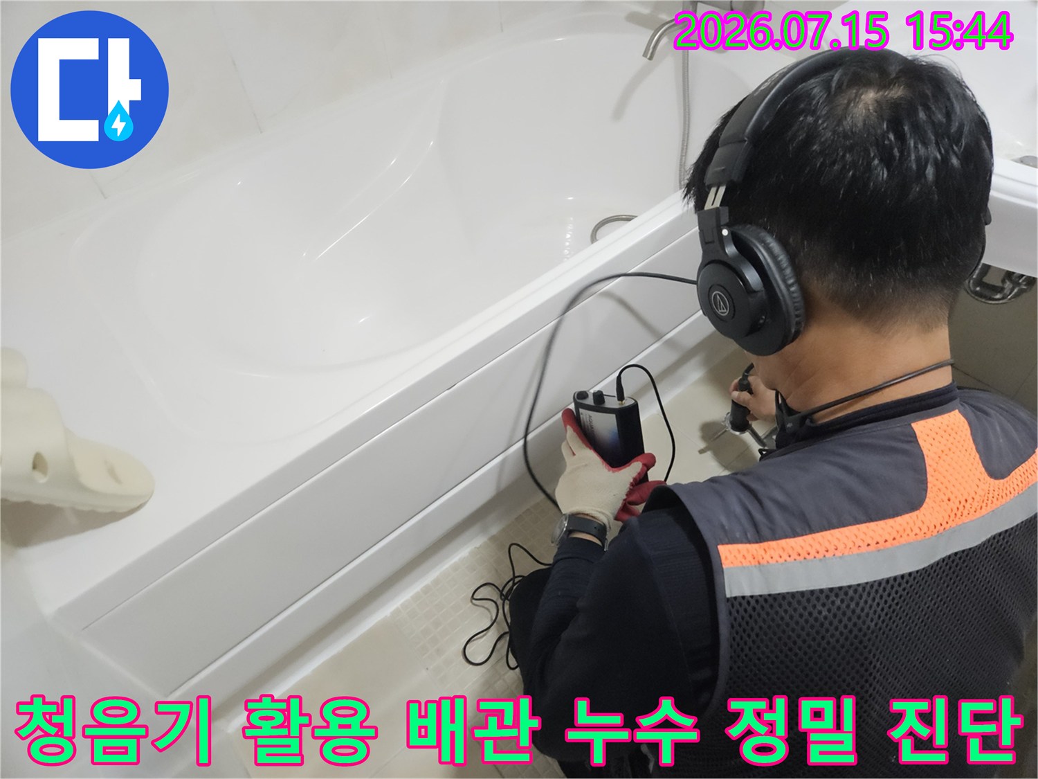 헤드셋형 청음 장비를 사용하여 욕실 내 수도 배관의 파손 지점을 추적하는 기술자