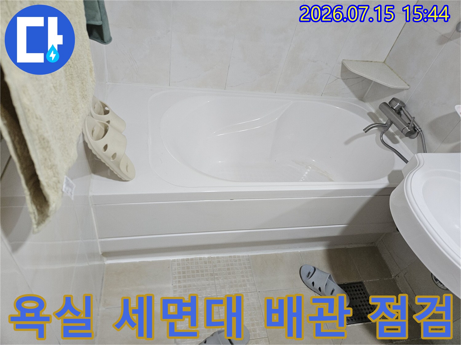 흰색 욕실 내부에 설치된 세면대와 하부 배관 구조