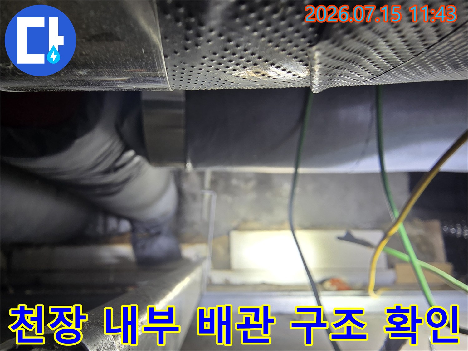 회색 보온재로-감싸진 천장 배관과 노란 전선들이 배치된 모습