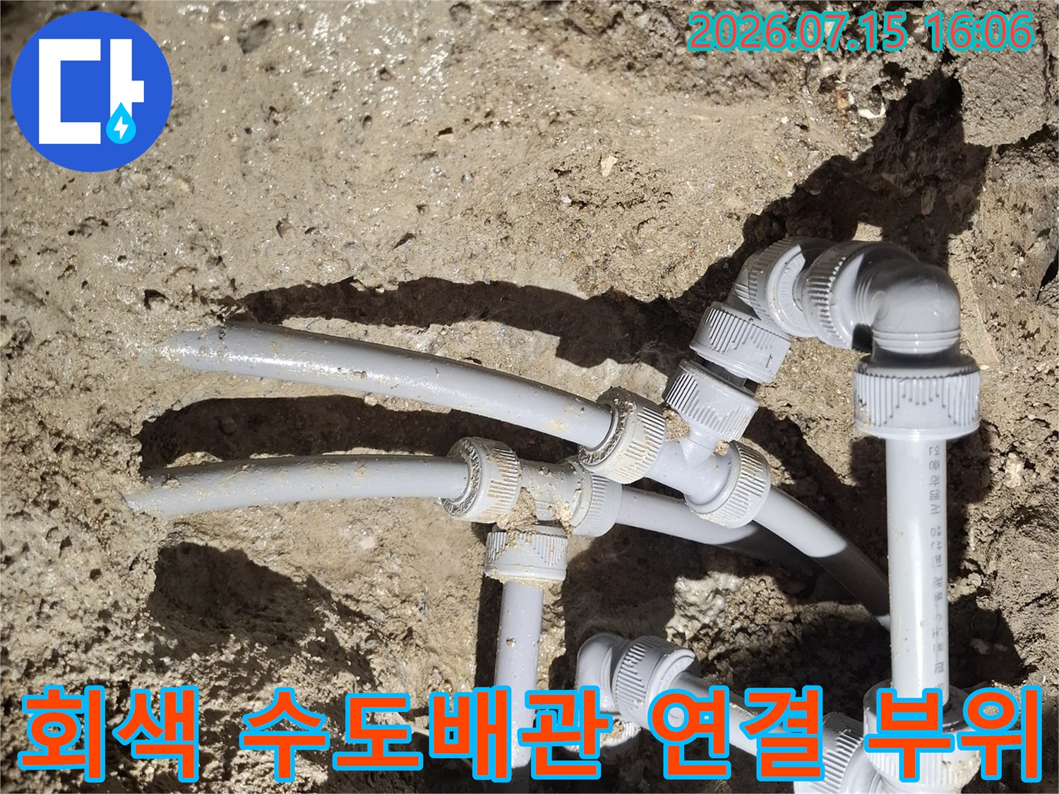 땅속에 매립된 회색 플라스틱 수도 배관과 연결 부속들이 복잡하게 얽혀 있는 모습