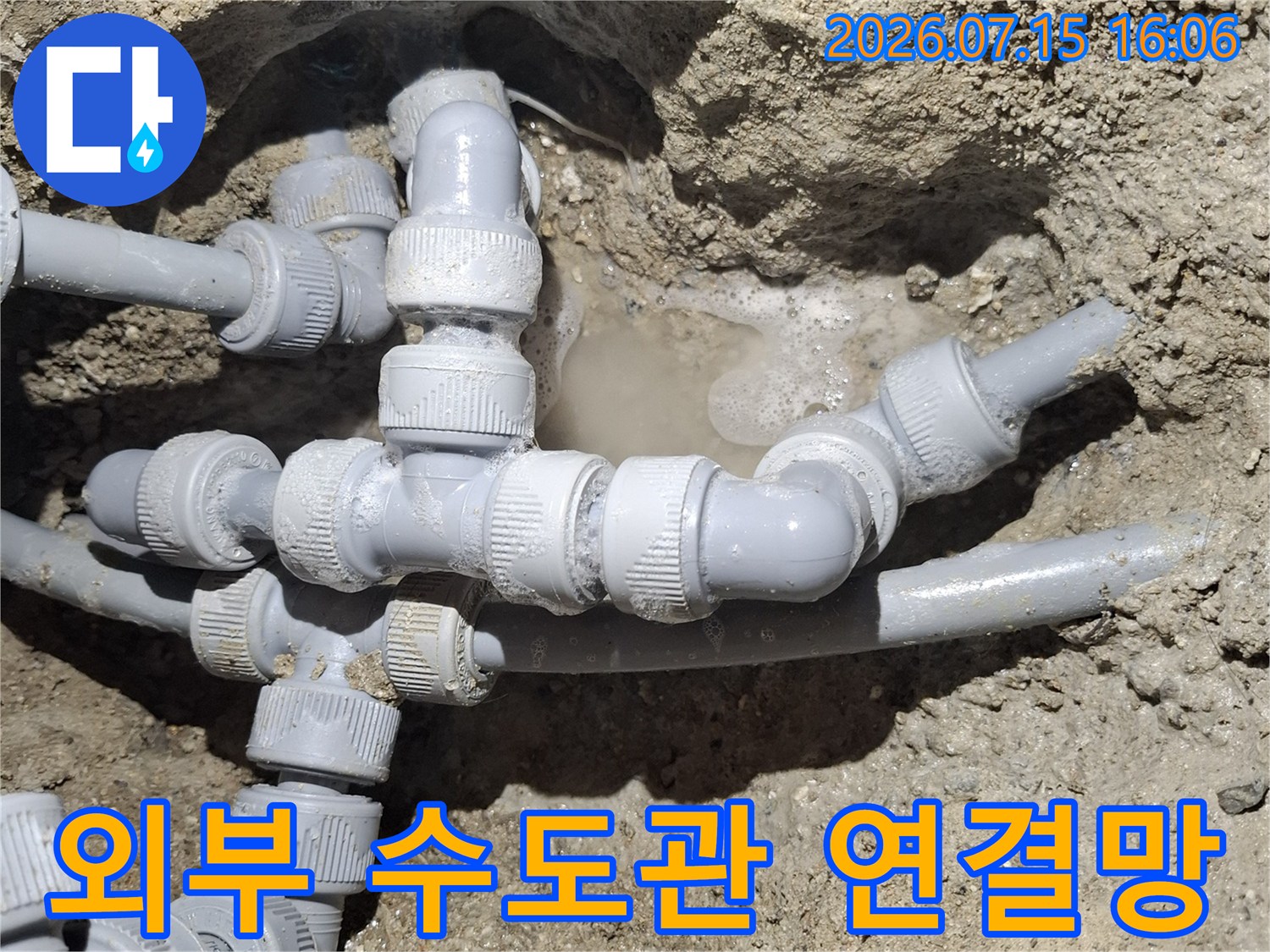 땅속에서 발견된 복잡하게 연결된 회색 플라스틱 상수도 배관들