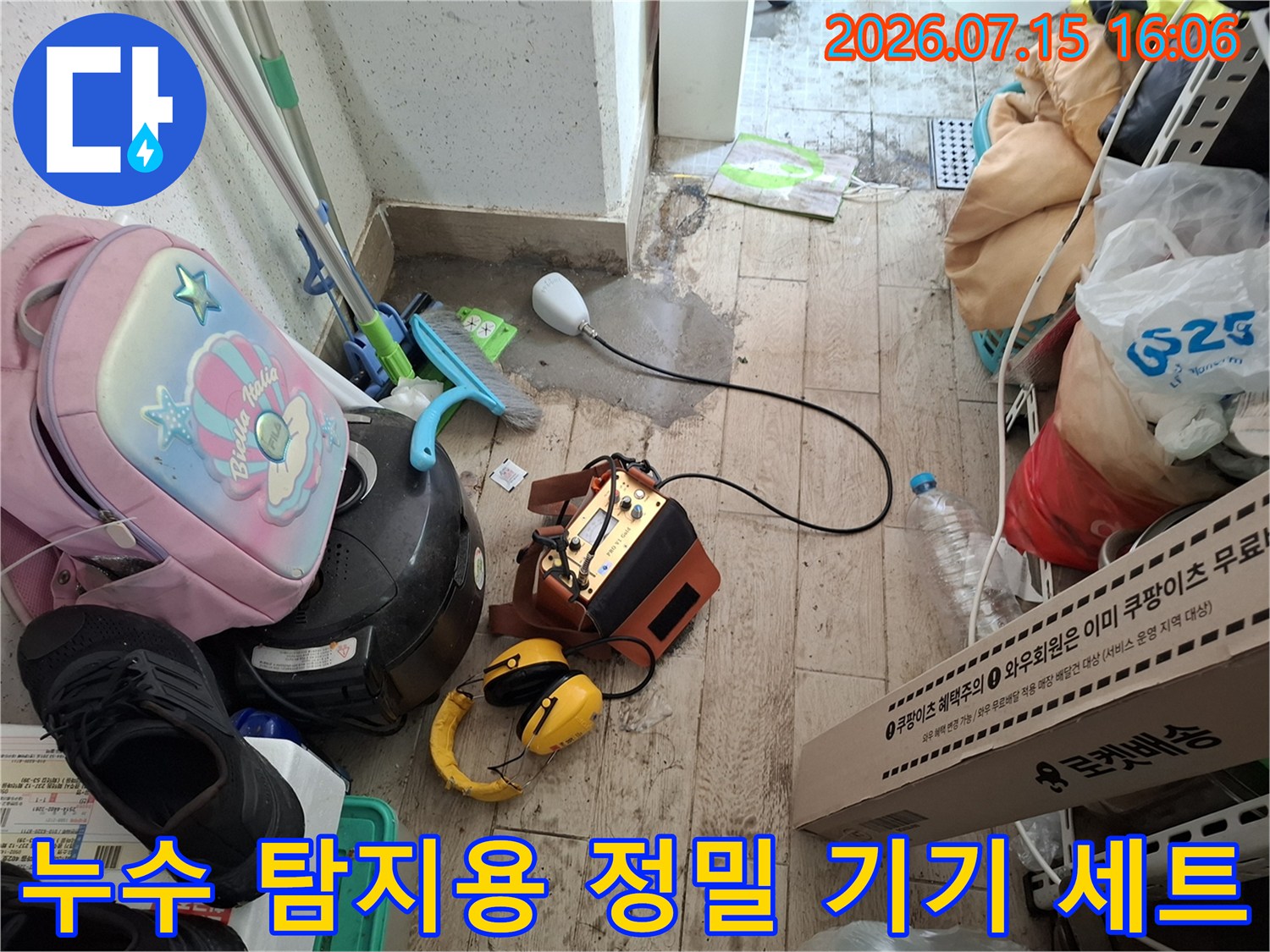 바닥에 놓인-누수탐지 본체와 연결된 측정 센서 및 노란 헤드셋
