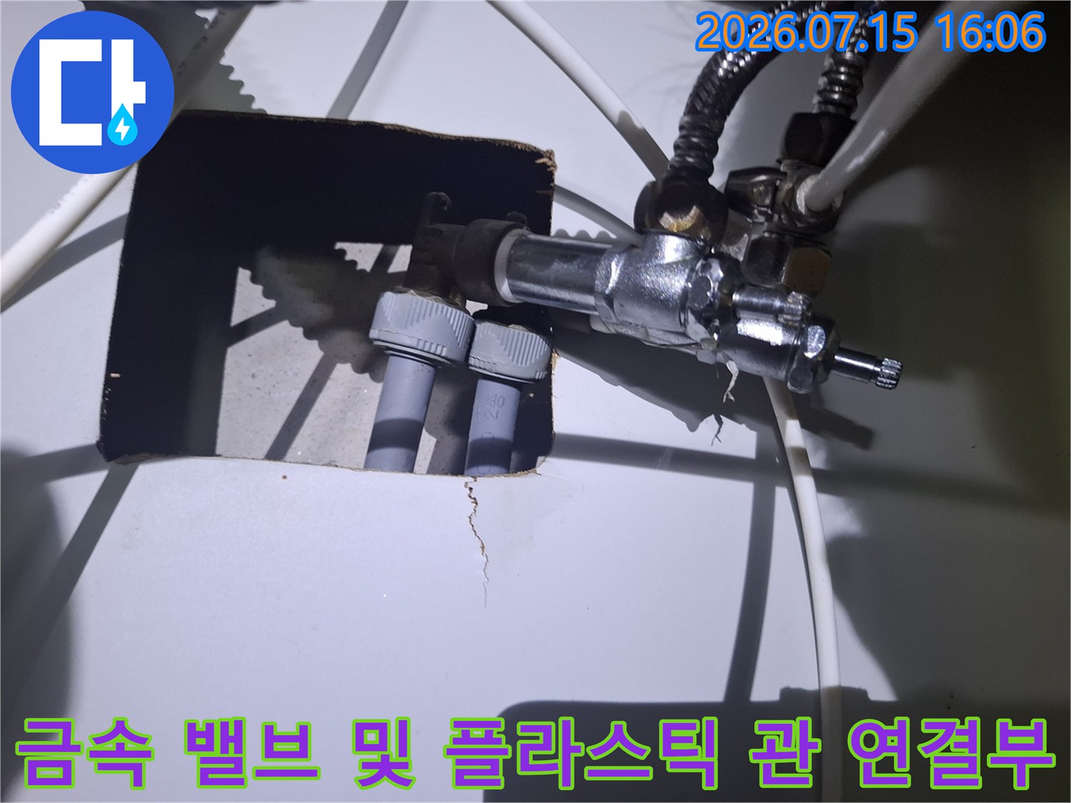 은색 금속 제어 밸브와 흰색 플라스틱 배관의 접합 부위-누수 점검 사진