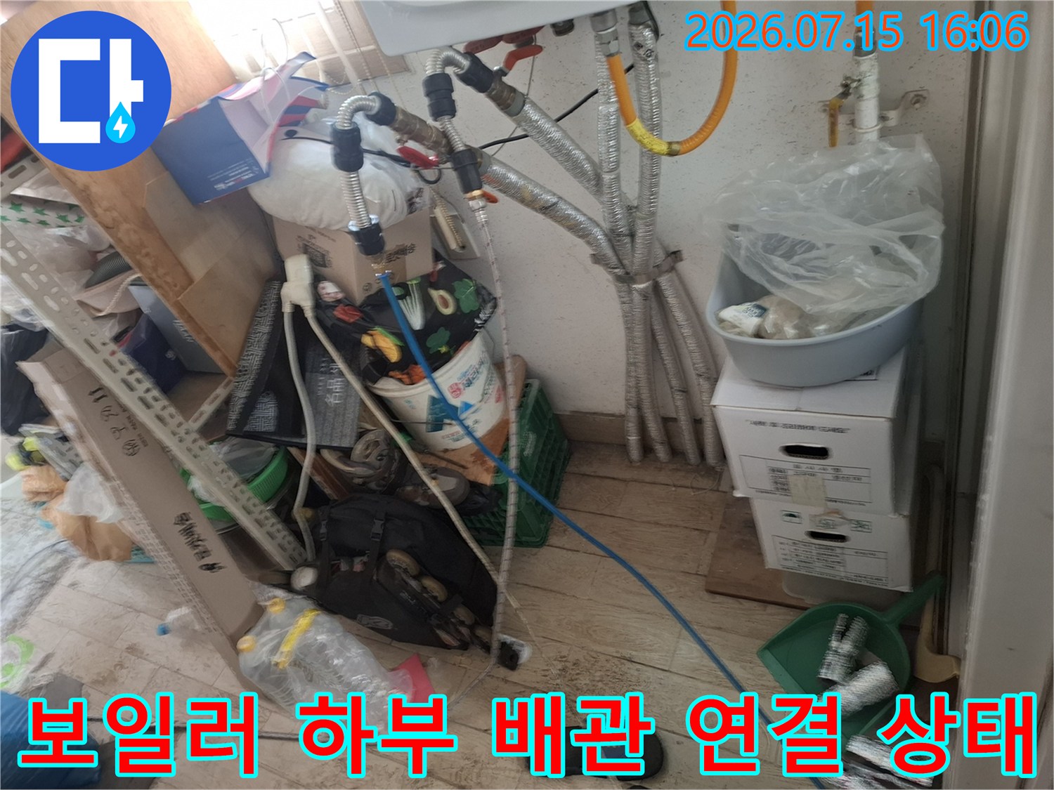 은색 주름관과 파란색 호스가 복잡하게 얽혀 내려오는 보일러 하단-누수 점검 현장 사진