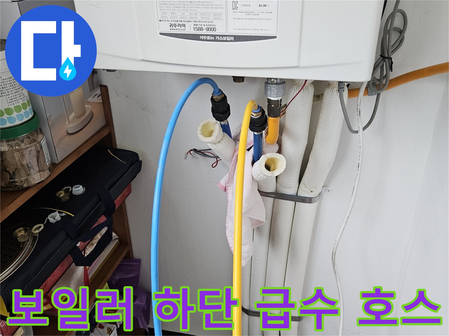 보일러 아래쪽의 노란색 및 파란색 배관과 흰색 연결 부속