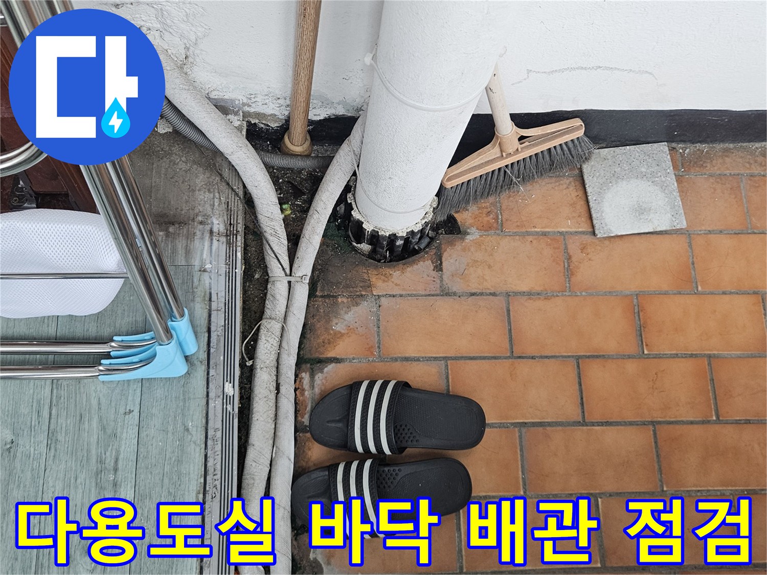 다용도실 하수구 주변의 젖은 타일과 배관 상태