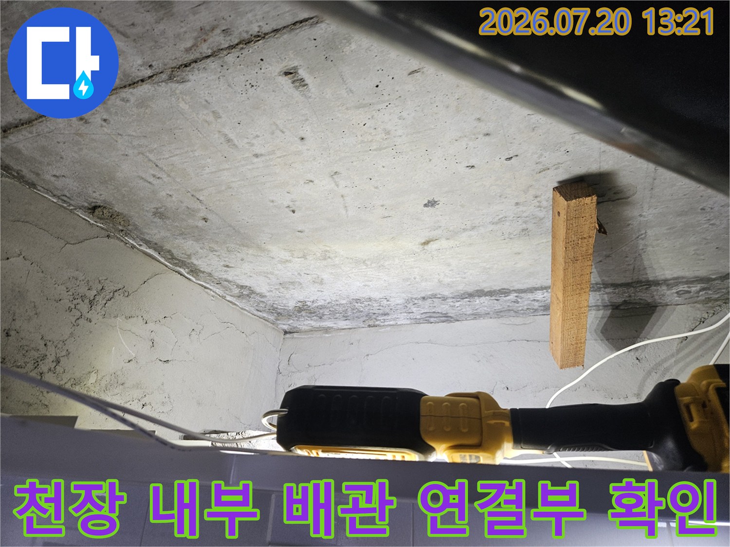 어두운 천장 안쪽 공간에서 배관의 상태와 주변 환경을 조사하는 모습