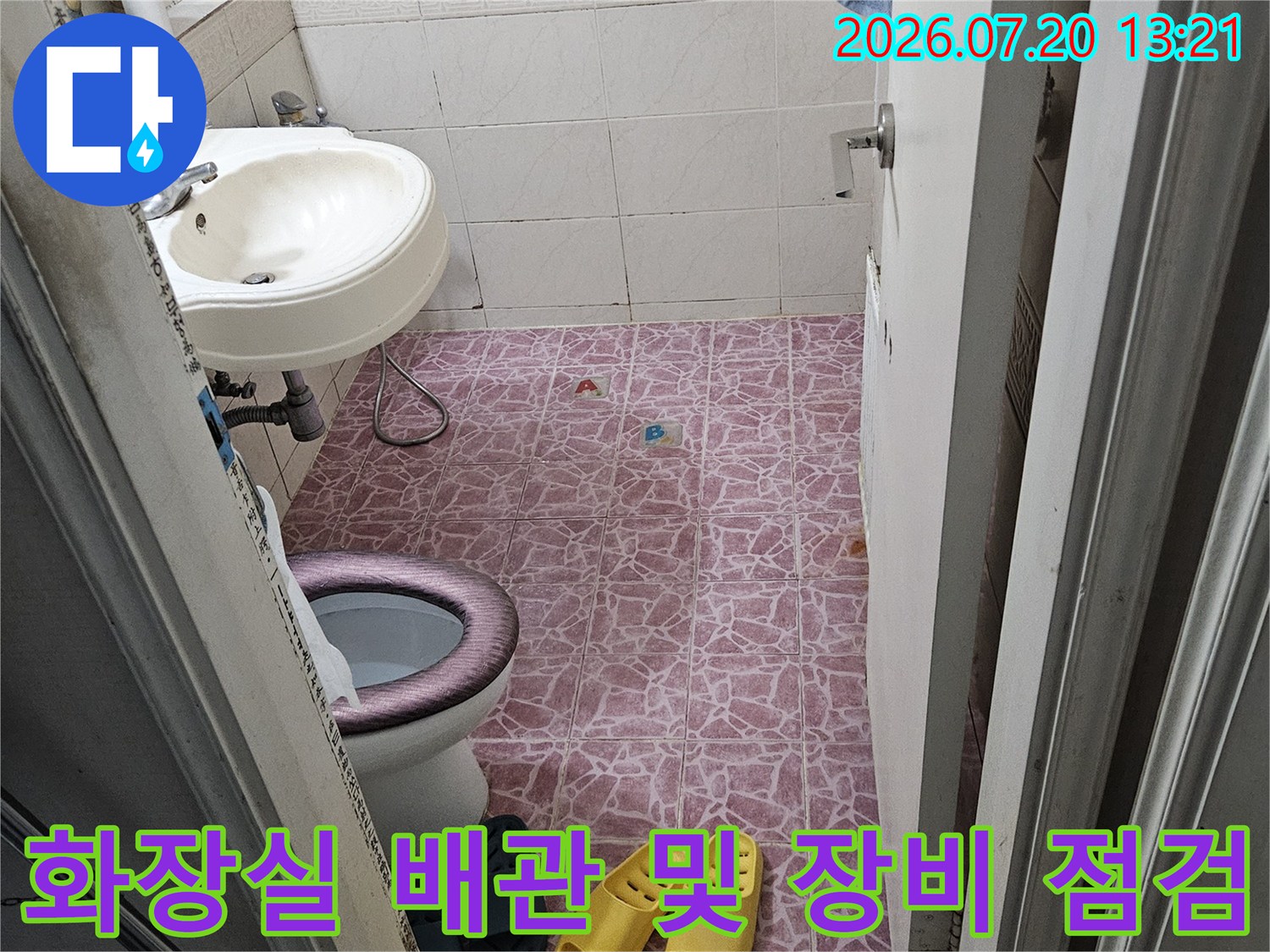화장실 바닥의 노출된 배관과 진단용 롤러 장비를 배치한 현장 모습