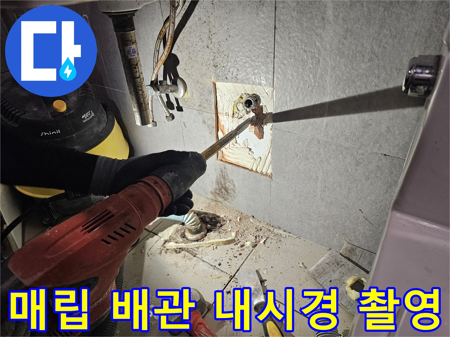 배관 입구에 내시경 카메라를 삽입하여 내부 상태를 점검하는 장면입니다.