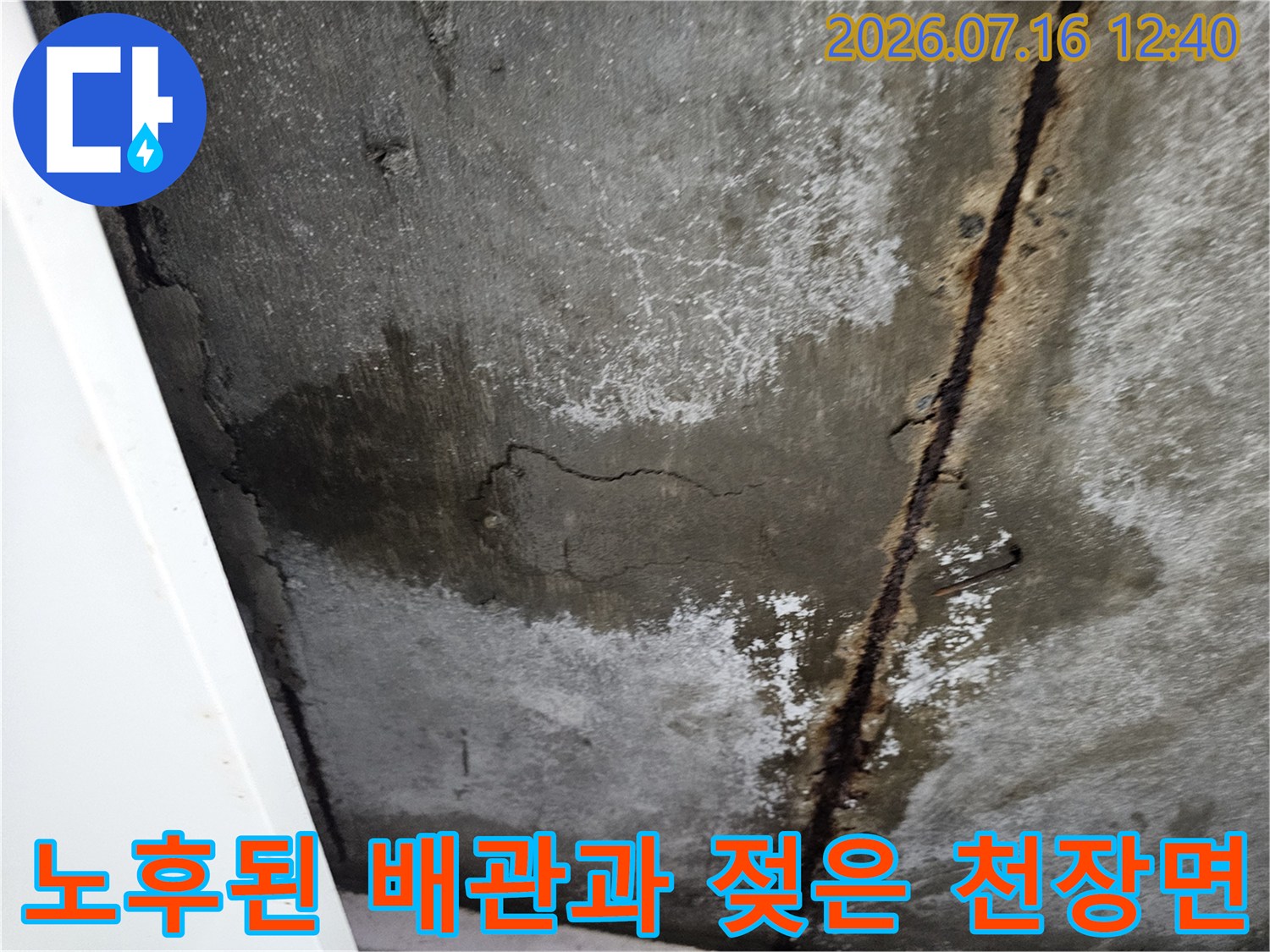 습기로 인해 변색되고 균열이 생긴 천장 콘크리트와 노출형 배관