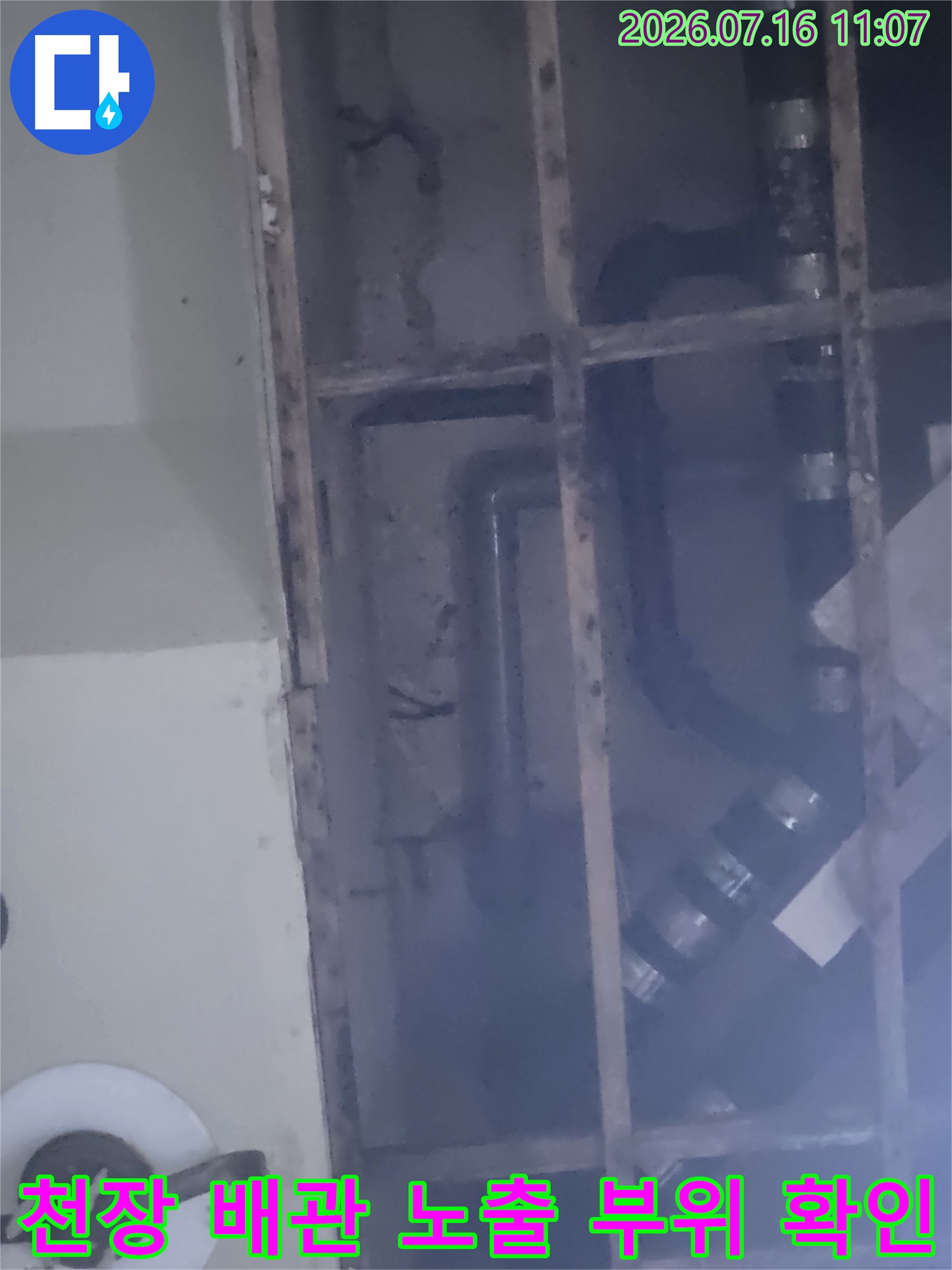 철제 프레임에 고정된 배관 시스템의 연결부와 굴곡진 구간을 상세히 점검하는 모습입니다.