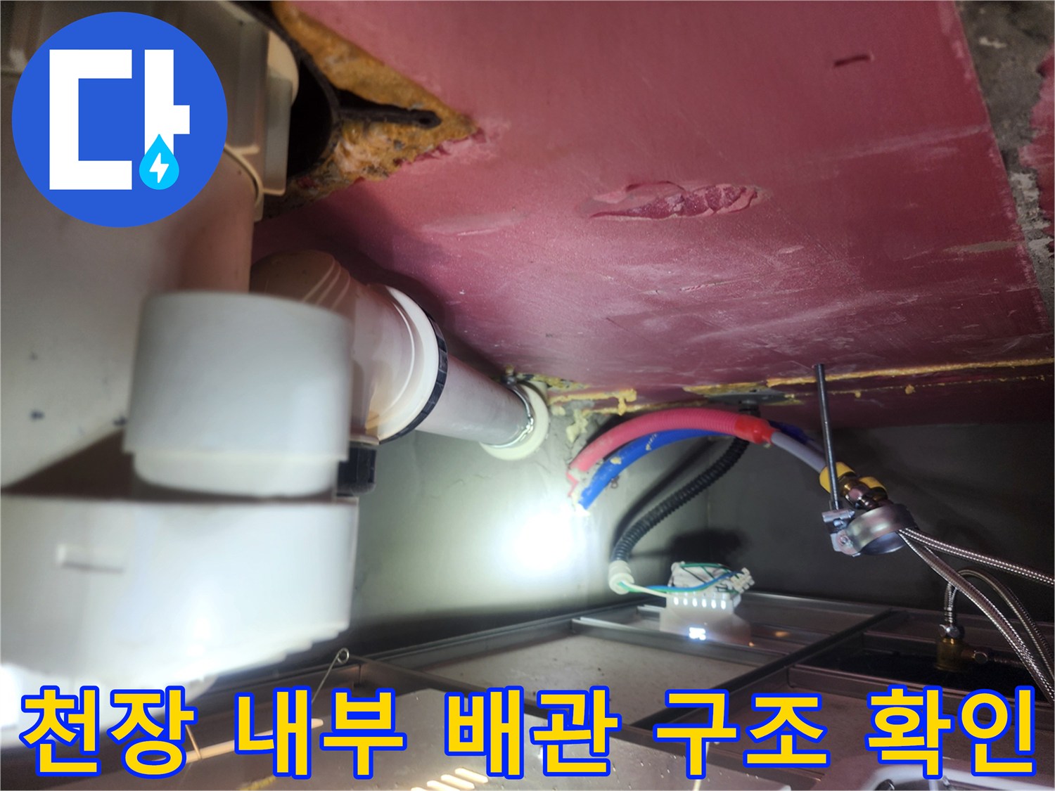 화장실 천장 점검구 내부의 배관과 전기 배선 모습