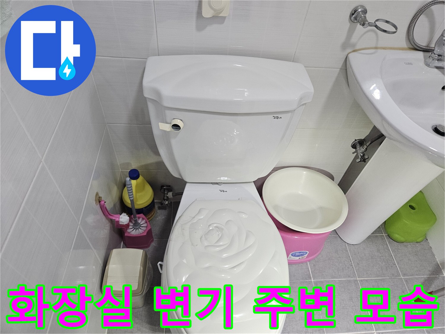 춘천 봉의동 화장실 내부의 변기와 세면대 주변 배관 상태를 촬영한 사진입니다.