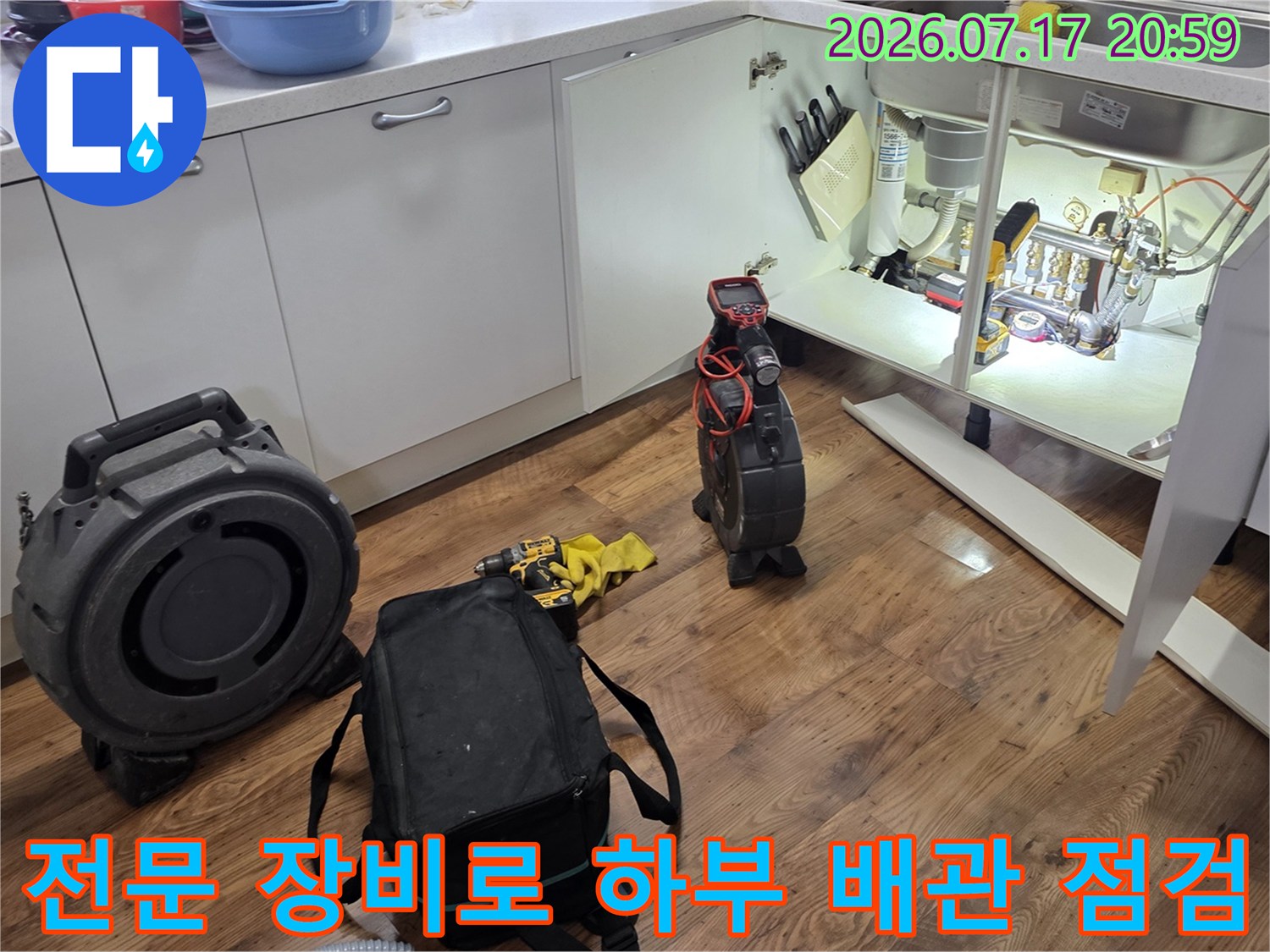 싱크대 아래 공간에서 전용 케이스와 탐지기를 사용하여 배관을 세밀하게 확인하는 과정