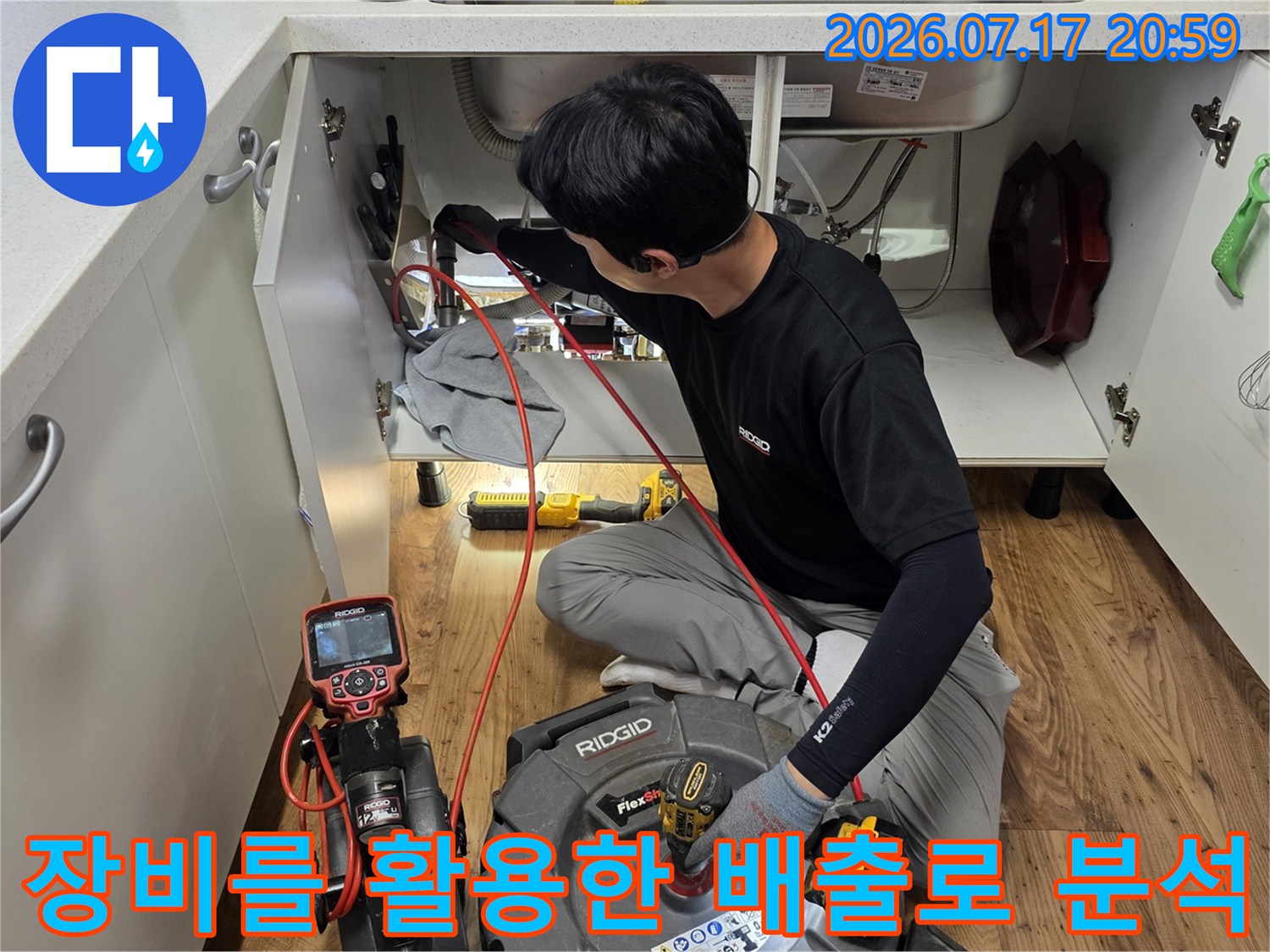 싱크대 아래 위치한 배관의 이상 징후를 전문 장비로 세밀하게 파악하는 장면