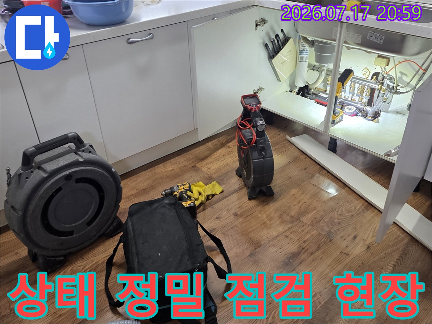싱크대 아래 위치한 배출 트럼 및 연결 배관을 전문 장비로 세부적으로 확인하는 모습