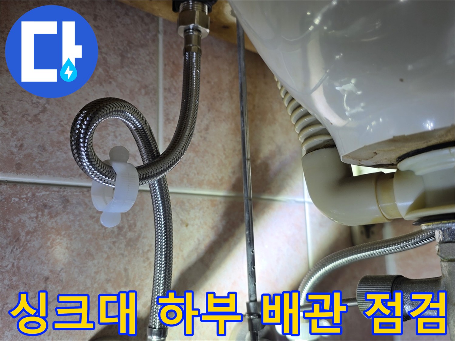 싱크대 아래쪽-연결된 금속 부품과 주름 호스 모습