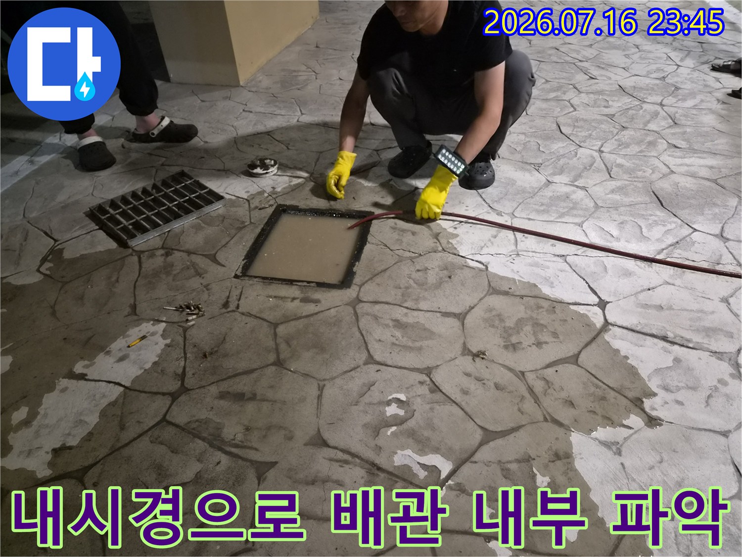 작업자가 장비를 이용해 배수구 안의 막힘 정도를 실시간 영상으로 확인하는 모습