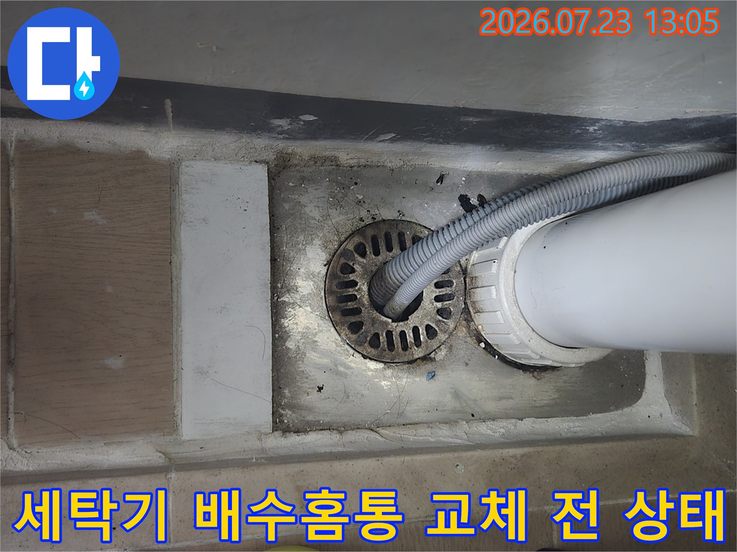 파손된 세탁실용 배수 홈통과 연결 파이프의 노후를 보여주는 사진