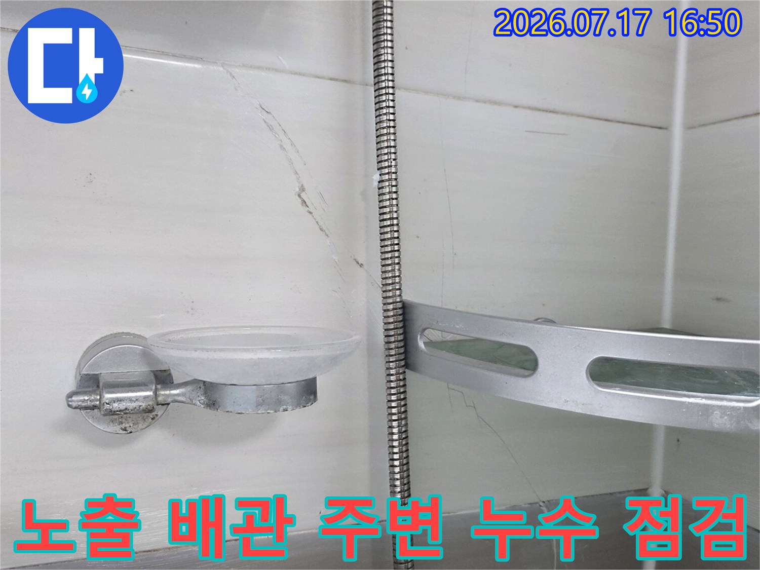화장실 천장 내 노출된 금속 배관과 타일 마감면의 상태를 기록한 사진