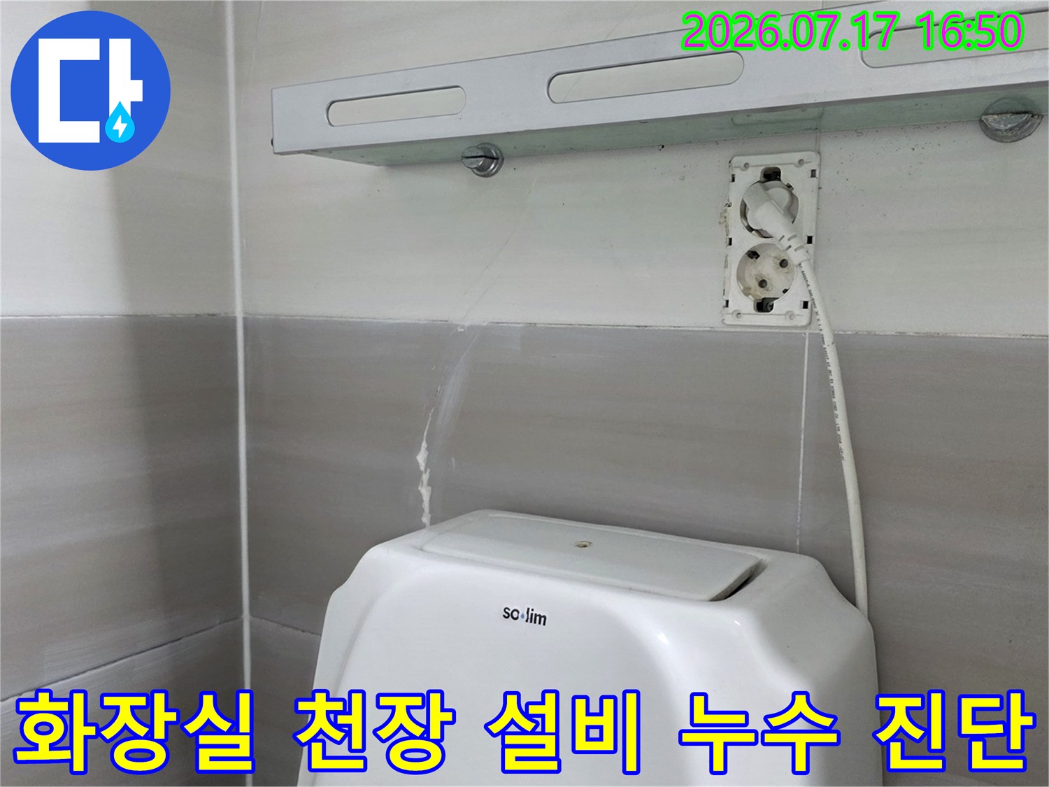 화장실 천장 내부에 노출된 배관과 전선 주변의 상태를 점검하는 전문 모습
