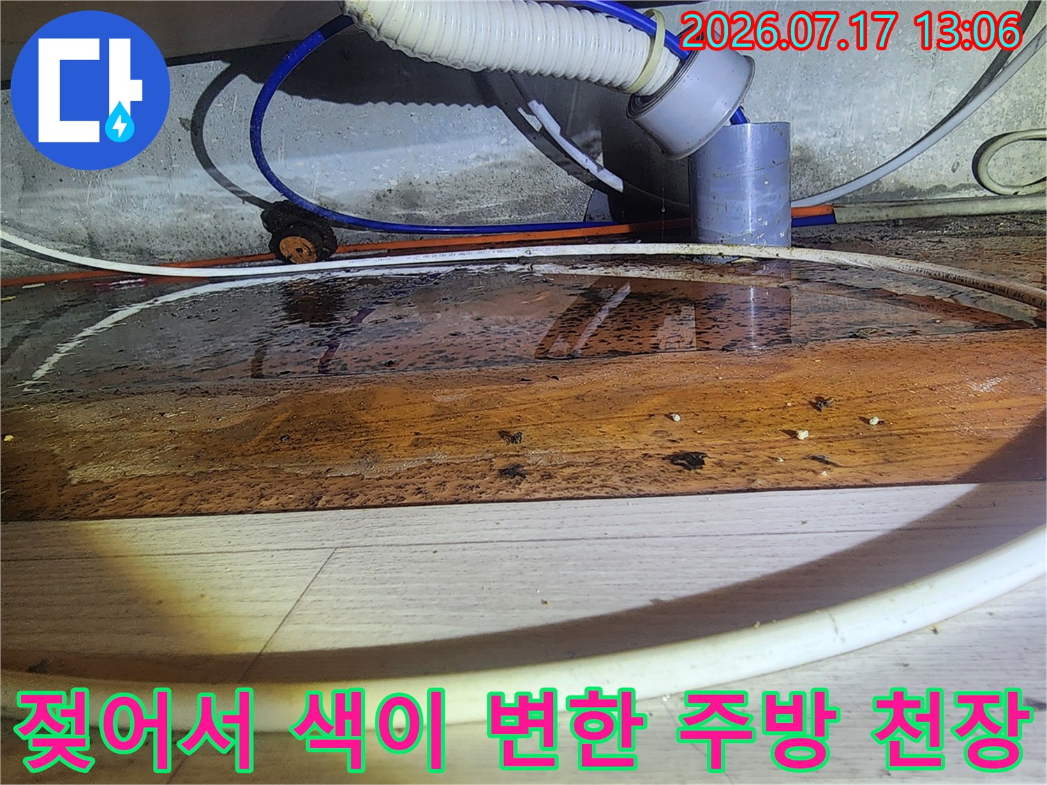 배관 주변의 나무 자재가 습기로 인해 갈색으로 짙게 변색된 모습