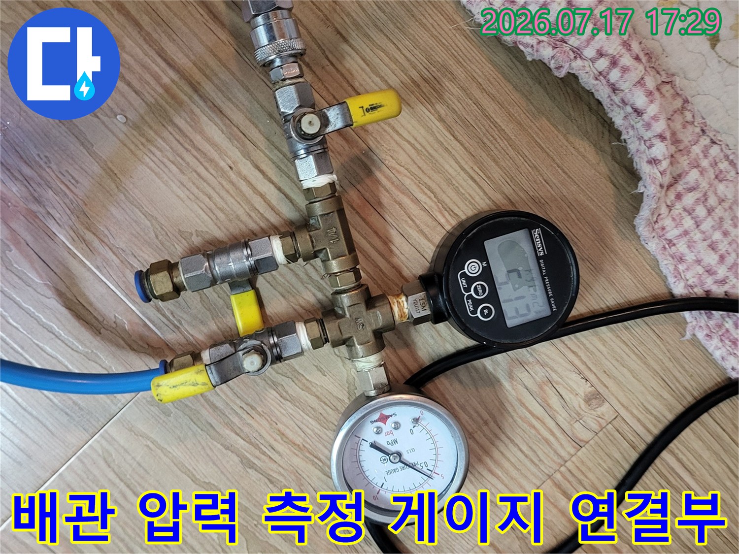 금속 피팅과 호스 그리고 디지털 수치 표시기가 결합된 누수 탐지 장비의 상세 모습
