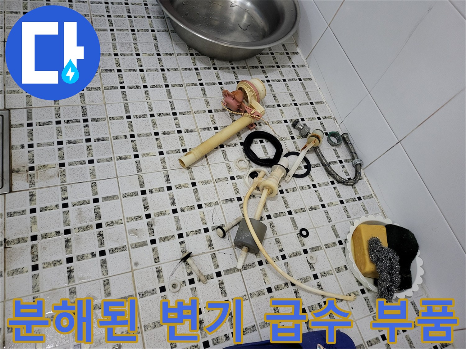 화장실 타일 위로 놓인 낡은 수도 연결 호스와 밸브 세트