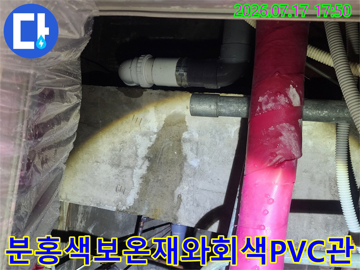 천장 내부의 분홍색 보온재 배관과 그 아래로 연결된 회색 PVC 배수관-누수 지점 촬영
