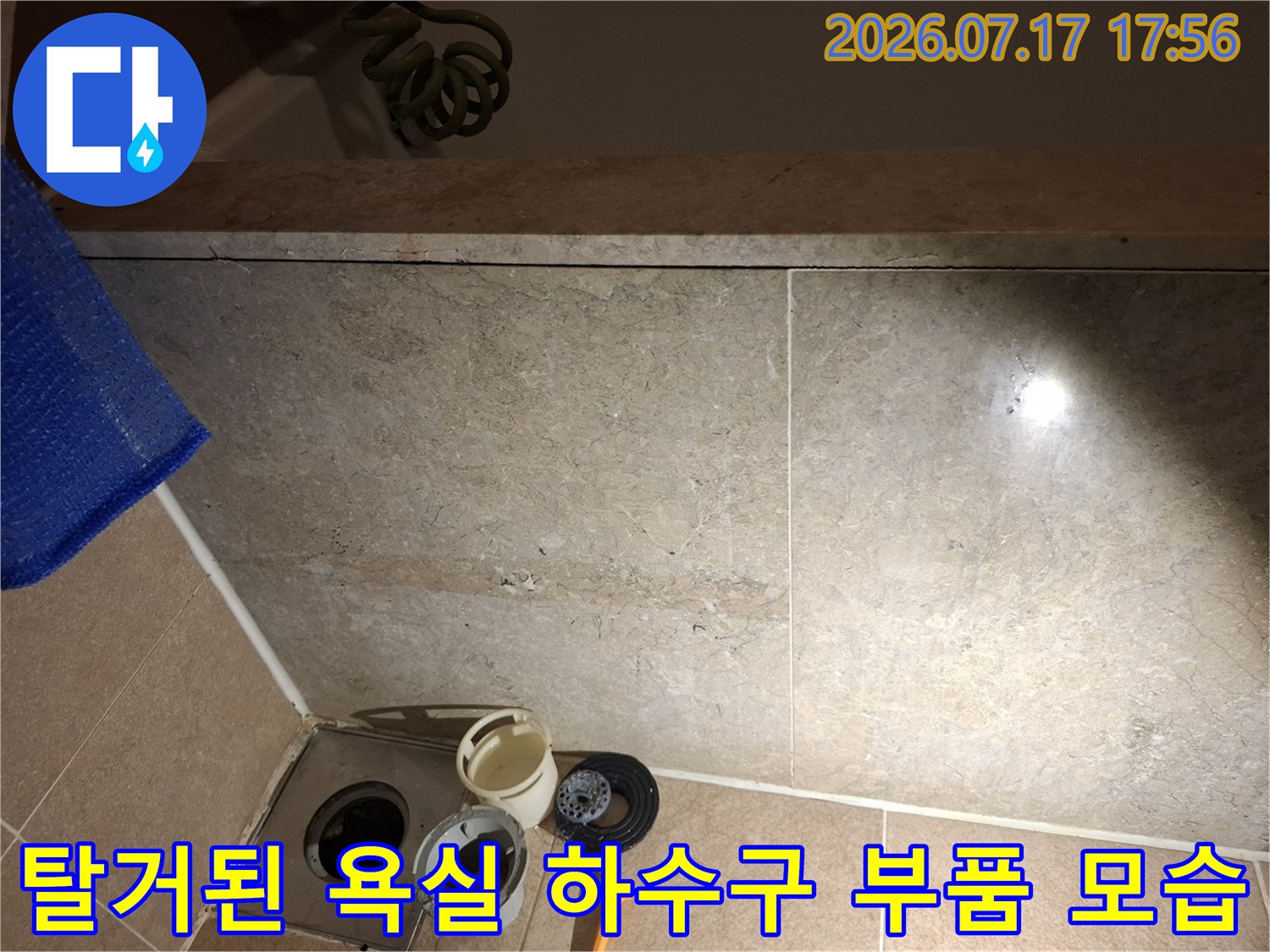 욕실-타일-위에-금속-유가-프레임과-분리된-흰색-플라스틱-배관-소켓들이-놓여있는-사진