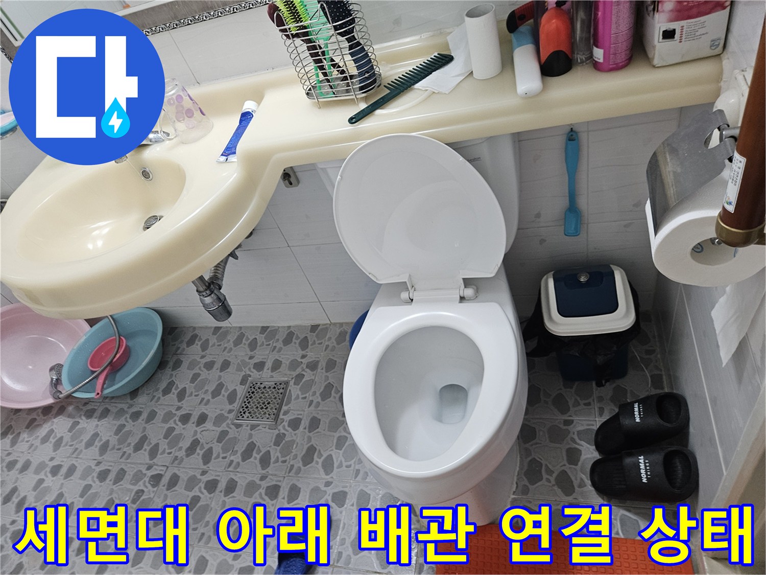 변기 주변과 세면대 하부 배관의 근접 촬영 사진