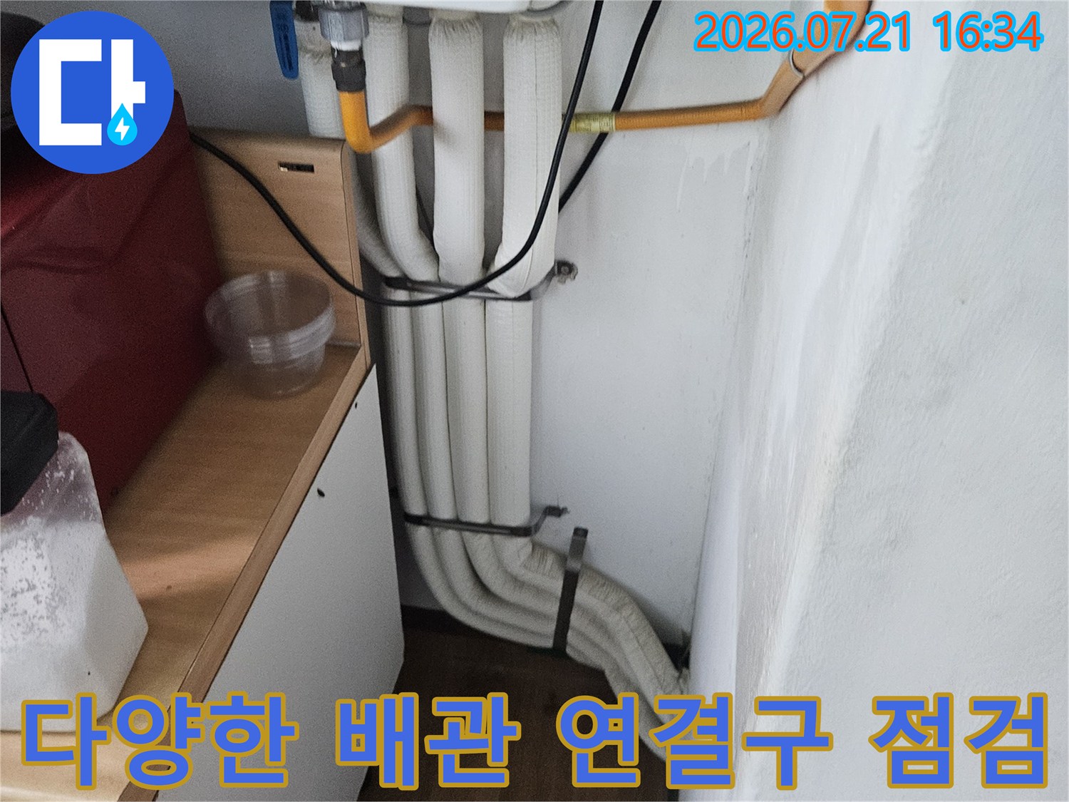 세면대 하부에 위치한 다수의 수도 배관과 유연 호스들 점검