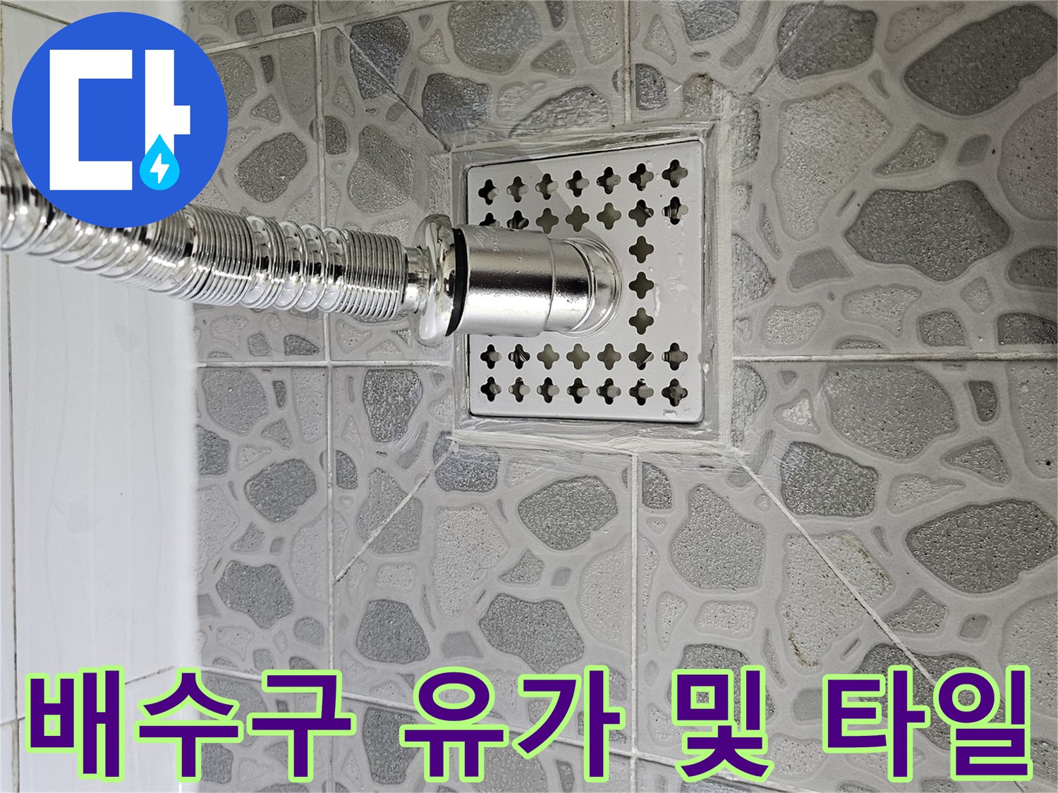 화장실 배수구 부속과 주변 타일의 접합 상태를 나타내는 사진